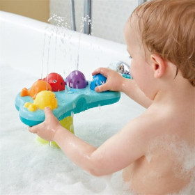 Enfant jouant avec la fontaine de bain musicale Hape